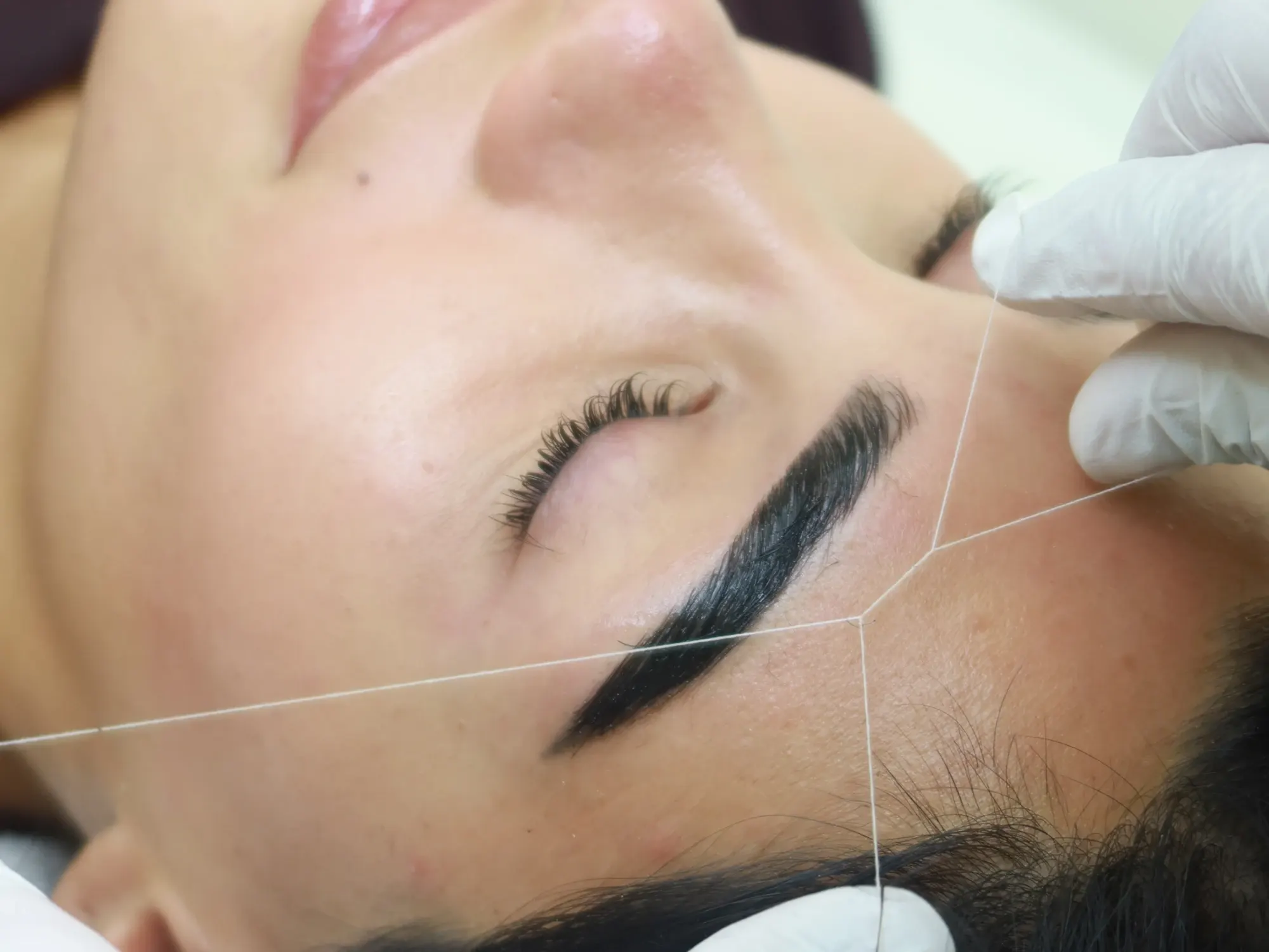 Brow threading in progress at AZIZAM beauty salon in Dubai